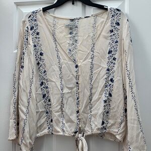 Cropped deep V ‘70s inspired boho top. Cream and blue floral